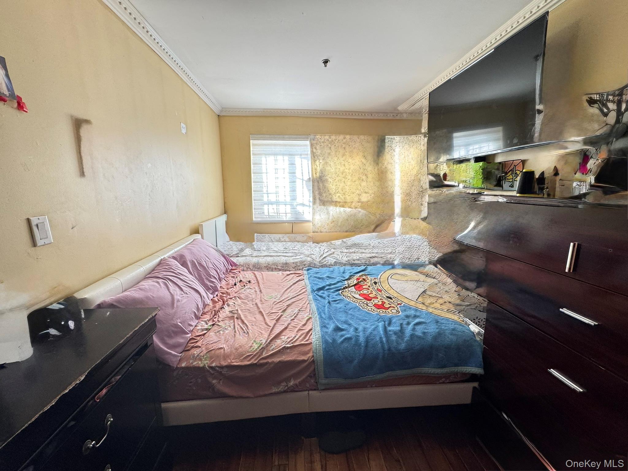 104-21 39th Avenue, Unit 211C Queens, NY 11368 - Photo 11 of 15 a bedroom with a bed and a night stand