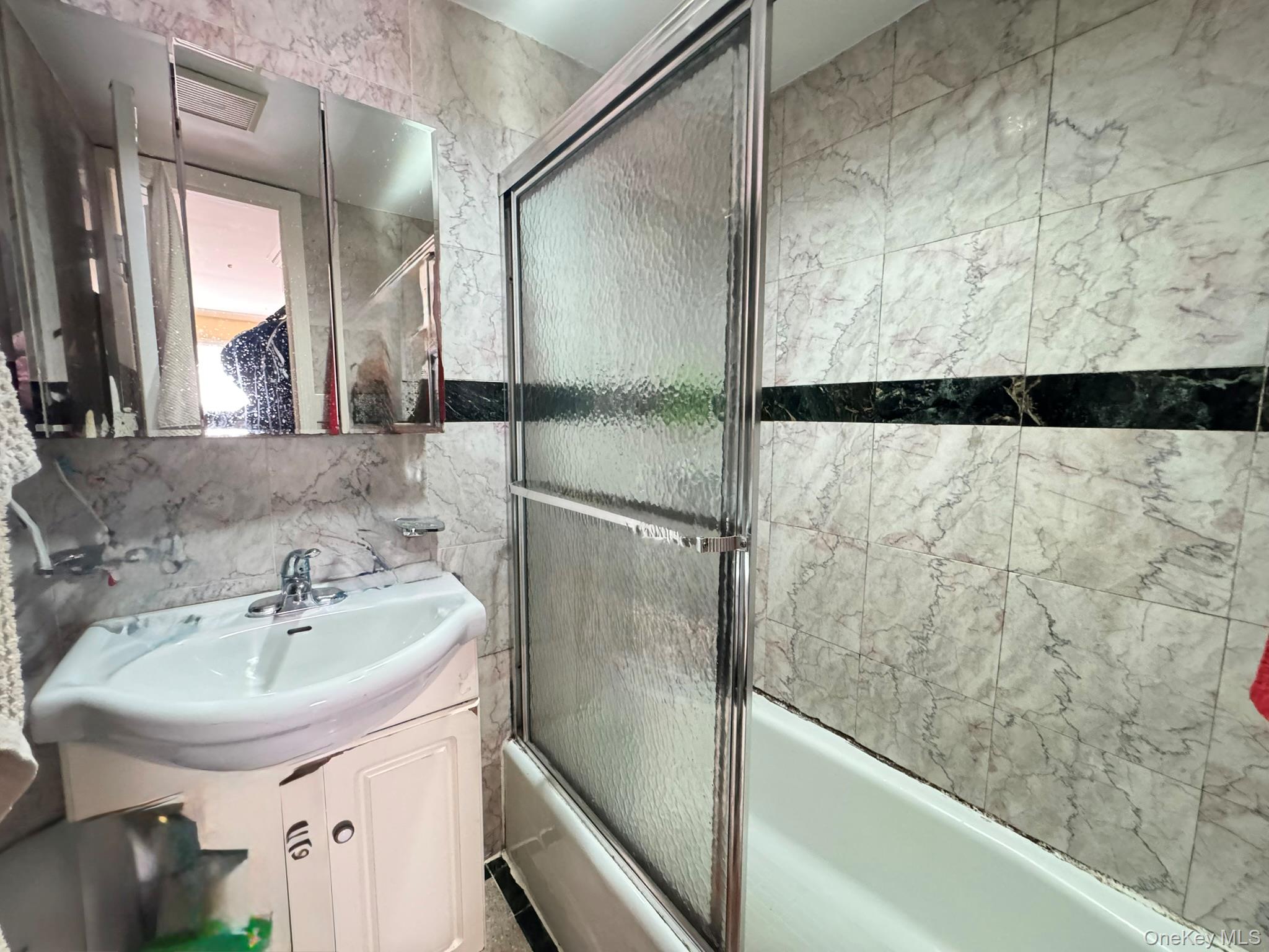 104-21 39th Avenue, Unit 211C Queens, NY 11368 - Photo 12 of 15 a bathroom with a sink and a bathtub