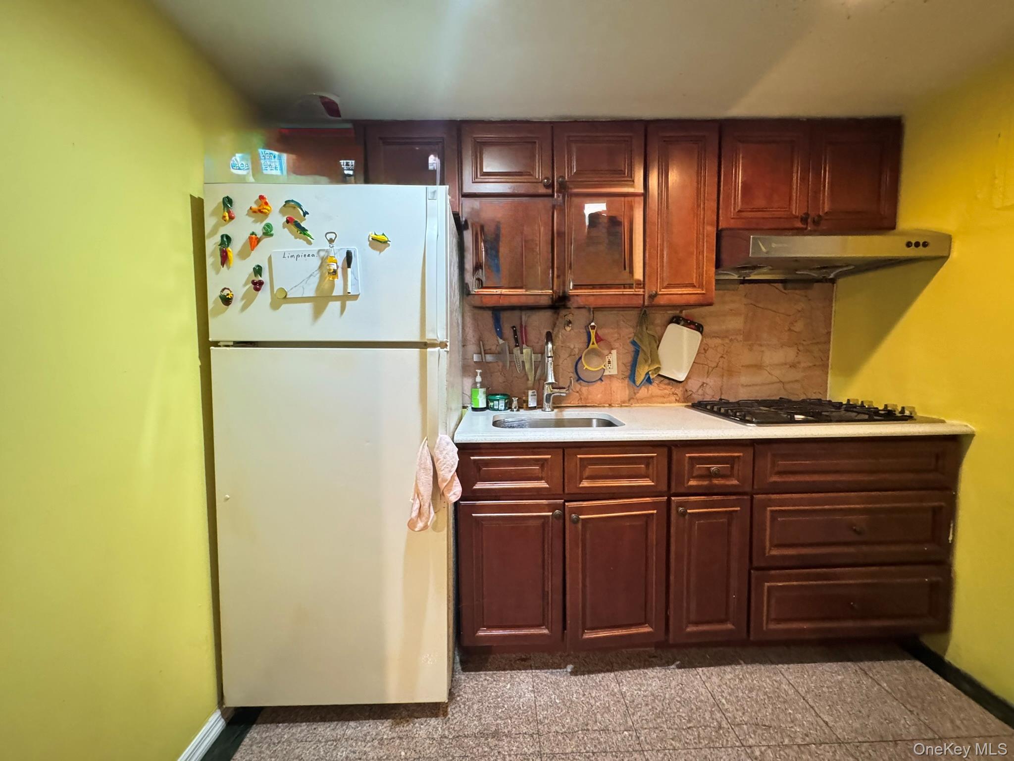 104-21 39th Avenue, Unit 211C Queens, NY 11368 - Photo 3 of 15 a kitchen with refrigerator and cabinets