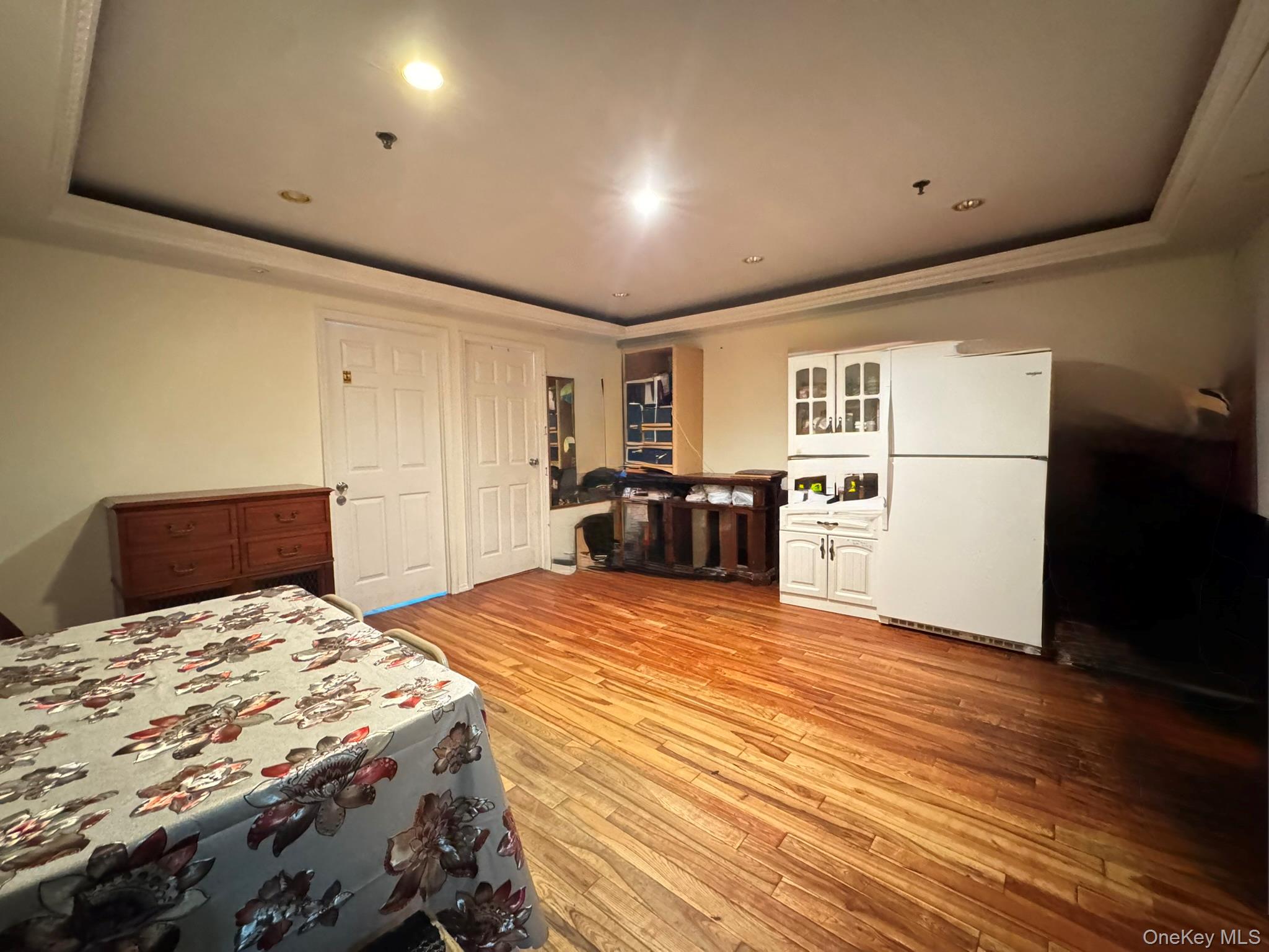 104-21 39th Avenue, Unit 211C Queens, NY 11368 - Photo 5 of 15 a large bedroom with a bed and wooden floor