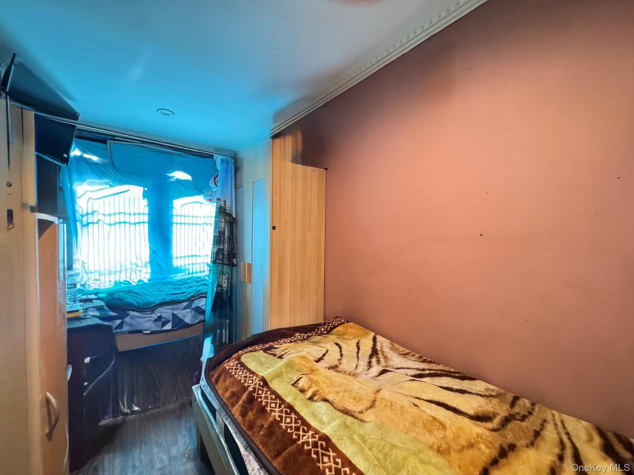 104-21 39th Avenue, Unit 211C Queens, NY 11368 - Photo 9 of 15 a bedroom with a bed and a window