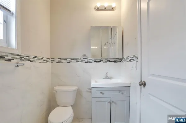 a bathroom with a toilet sink and mirror