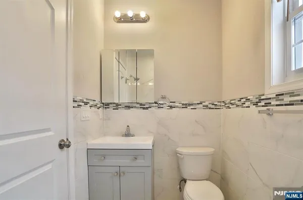 a bathroom with a toilet a sink and mirror