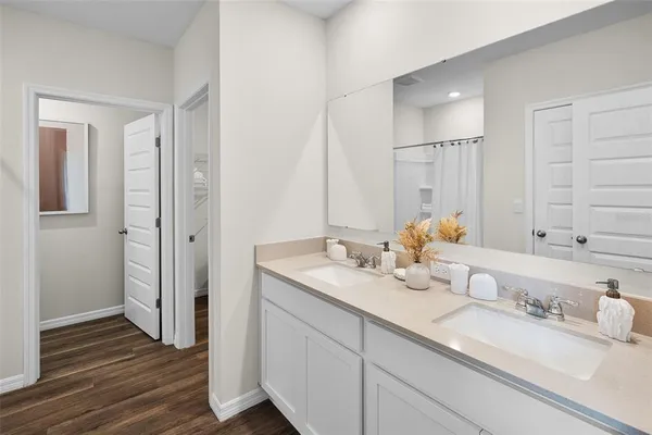 a bathroom with double vanity sinks and a mirror