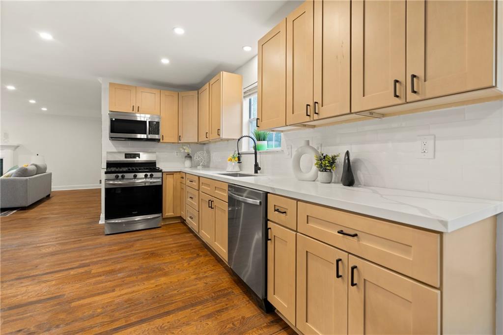 560 Flowering Trail Grayson, GA 30017 - Photo 13 of 68 a kitchen with stainless steel appliances granite countertop a stove a sink and white cabinets