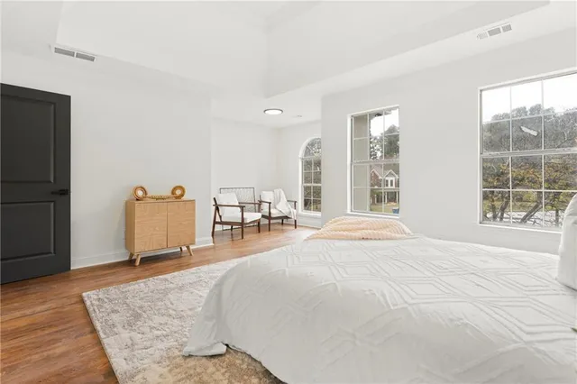 an empty room with wooden floor fan and windows