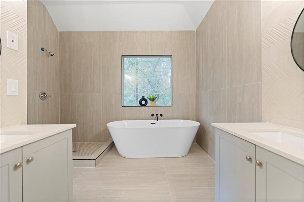 560 Flowering Trail Grayson, GA 30017 - Photo 32 of 68 a bathroom with a sink a mirror and a bathtub