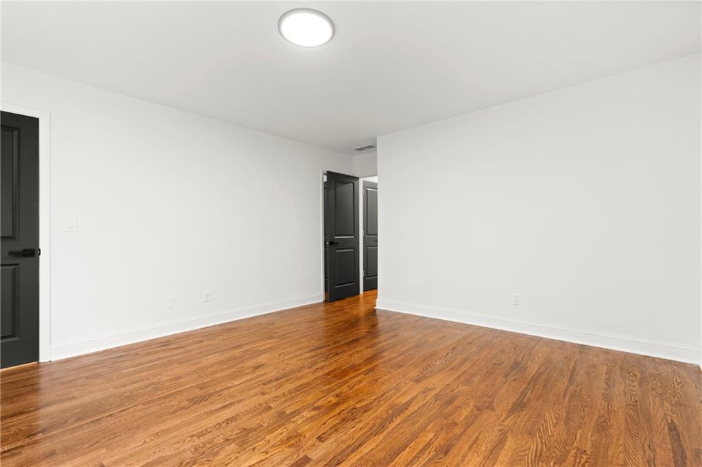 560 Flowering Trail Grayson, GA 30017 - Photo 40 of 68 a view of an empty room with wooden floor and white walls
