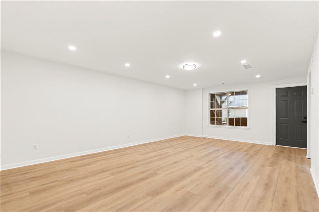 560 Flowering Trail Grayson, GA 30017 - Photo 43 of 68 an empty room with wooden floor and windows