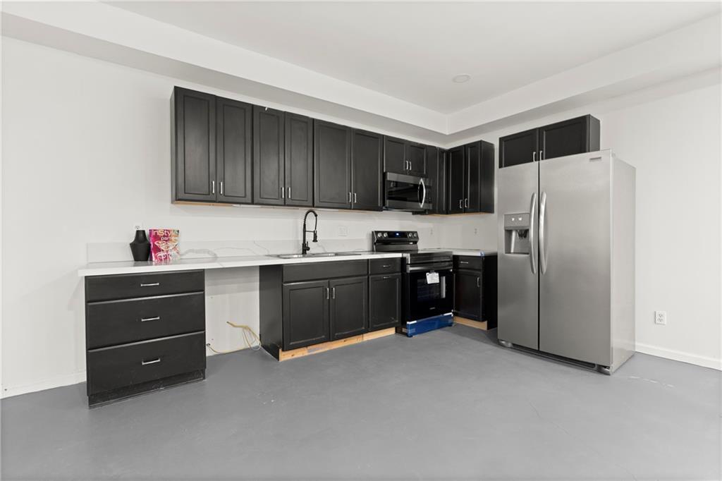 560 Flowering Trail Grayson, GA 30017 - Photo 55 of 68 a kitchen with granite countertop a refrigerator and a stove top oven