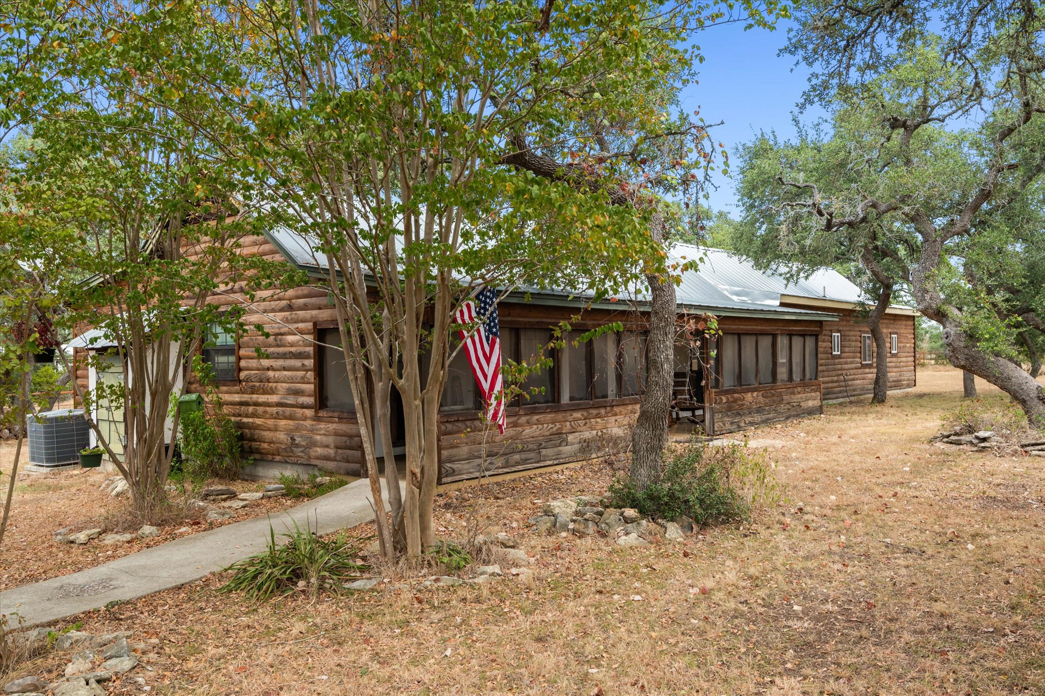 215 Go Away Road Blanco, TX 78606 - Photo 6 of 30 Charming Hill Country home on 4.16 acres surrounded by mature oak trees — fully gated and fenced for privacy. Relax on the screened in front porch and enjoy sunrises and sunsets and wildlife in a tranquil relaxing setting. The address might be Go Away Road, but it’s the kind of place you’ll want to call home forever.