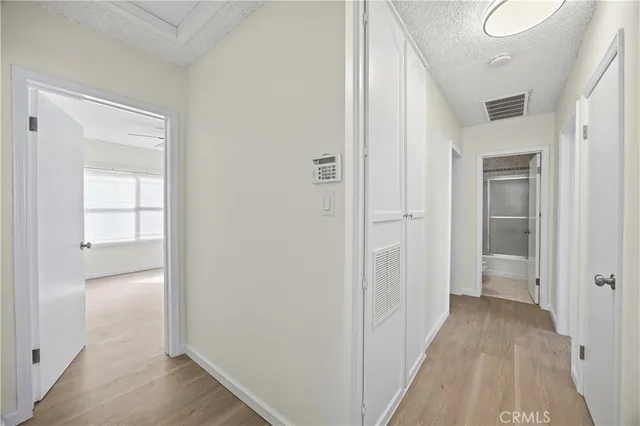 a view of a hallway with wooden floor and closet
