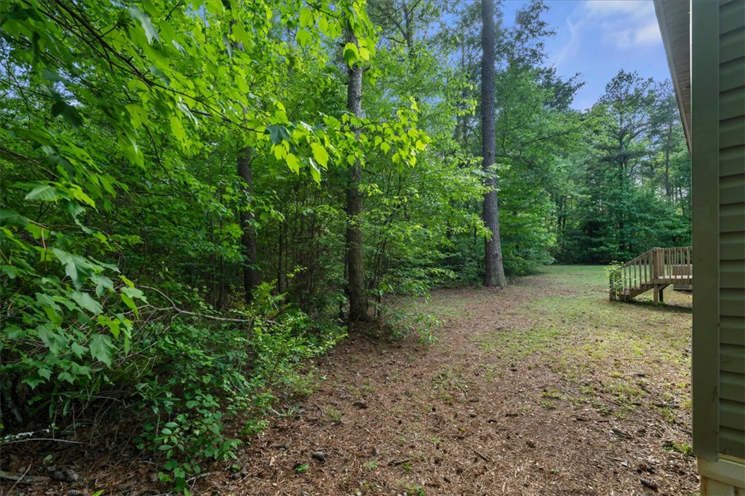 616 Anderson Road Pendleton, SC 29670 - Photo 21 of 29 This tranquil backyard retreat offers lush greenery and a charming wooden deck.