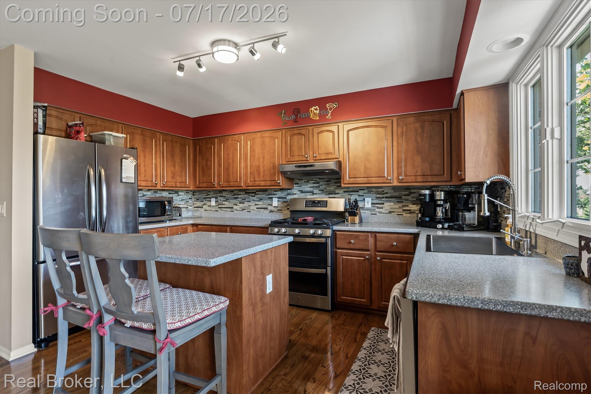 45192 Thornhill Road Canton, MI 48188 - Photo 8 of 34 Kitchen featuring wood-finish cabinetry, stainless steel appliances, a multi-tone tile backsplash, light-toned countertops, and a center island with additional counter space