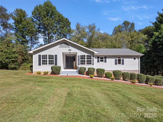 a front view of a house with a yard and trees