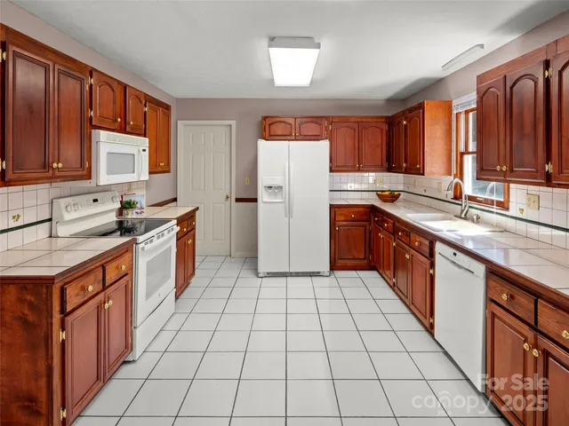 a large kitchen with stainless steel appliances granite countertop a sink and cabinets