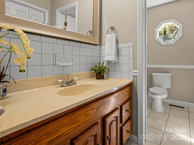 a bathroom with a sink a toilet and a mirror