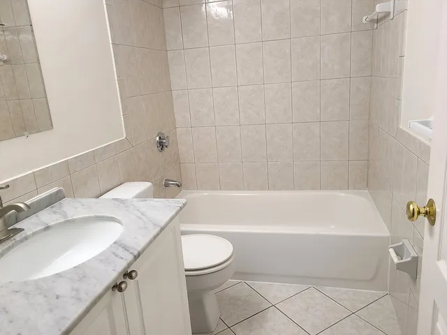 a bathroom with a granite countertop sink a toilet and bathtub