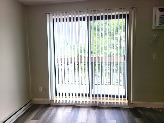 a view of wooden floor and a window in a room