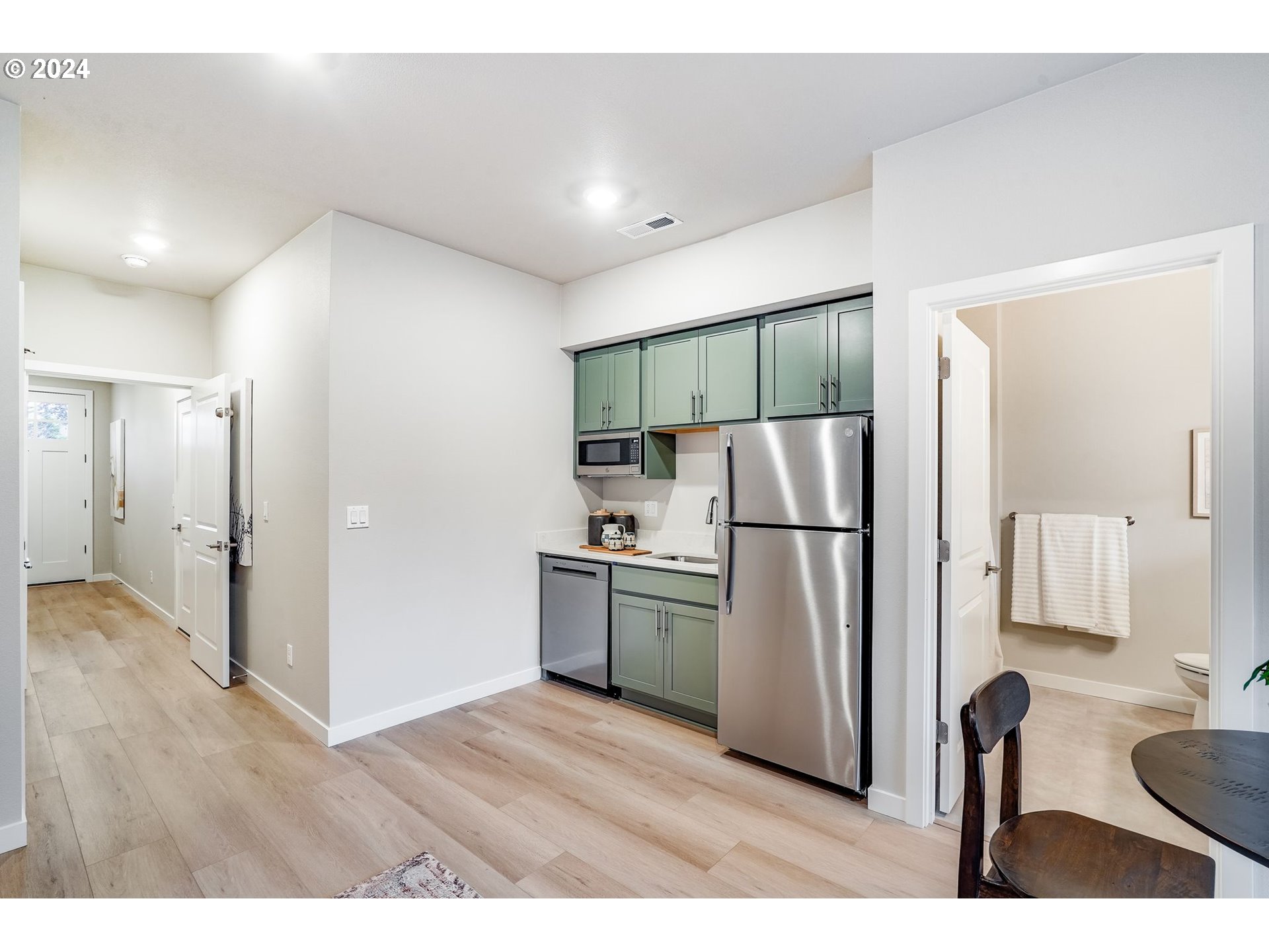 13167 Southwest Carmel Street Tigard, OR 97224 - Photo 12 of 48 a kitchen with refrigerator cabinets and wooden floor