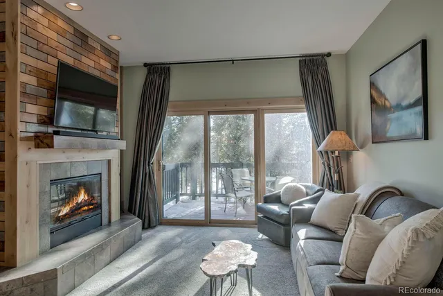a living room with furniture a flat screen tv and a fireplace