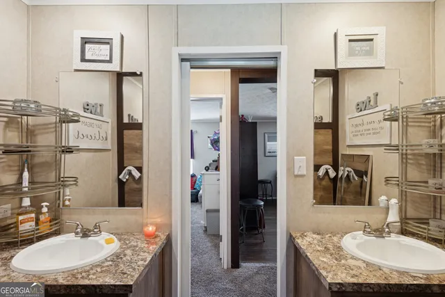 a bathroom with a granite countertop sink a mirror and shower