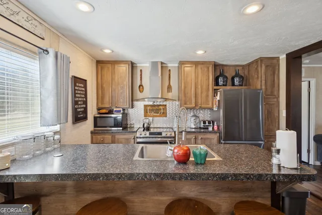 a kitchen with stainless steel appliances granite countertop a sink stove and refrigerator