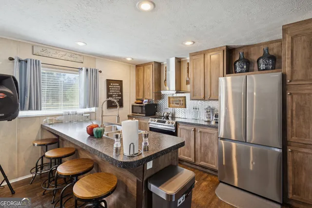 a kitchen with stainless steel appliances granite countertop a sink a stove and refrigerator