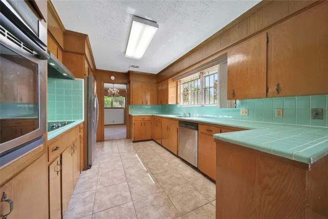 a kitchen with stainless steel appliances granite countertop a sink and a cabinets