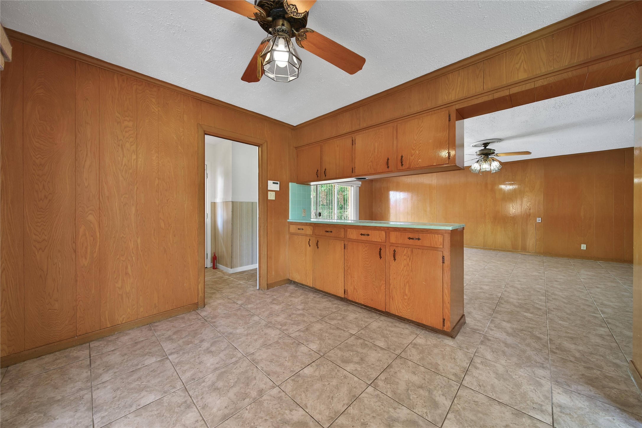 115 East Thornton Road Houston, TX 77022 - Photo 15 of 40 a view of a kitchen with a fridge and a ceiling fan