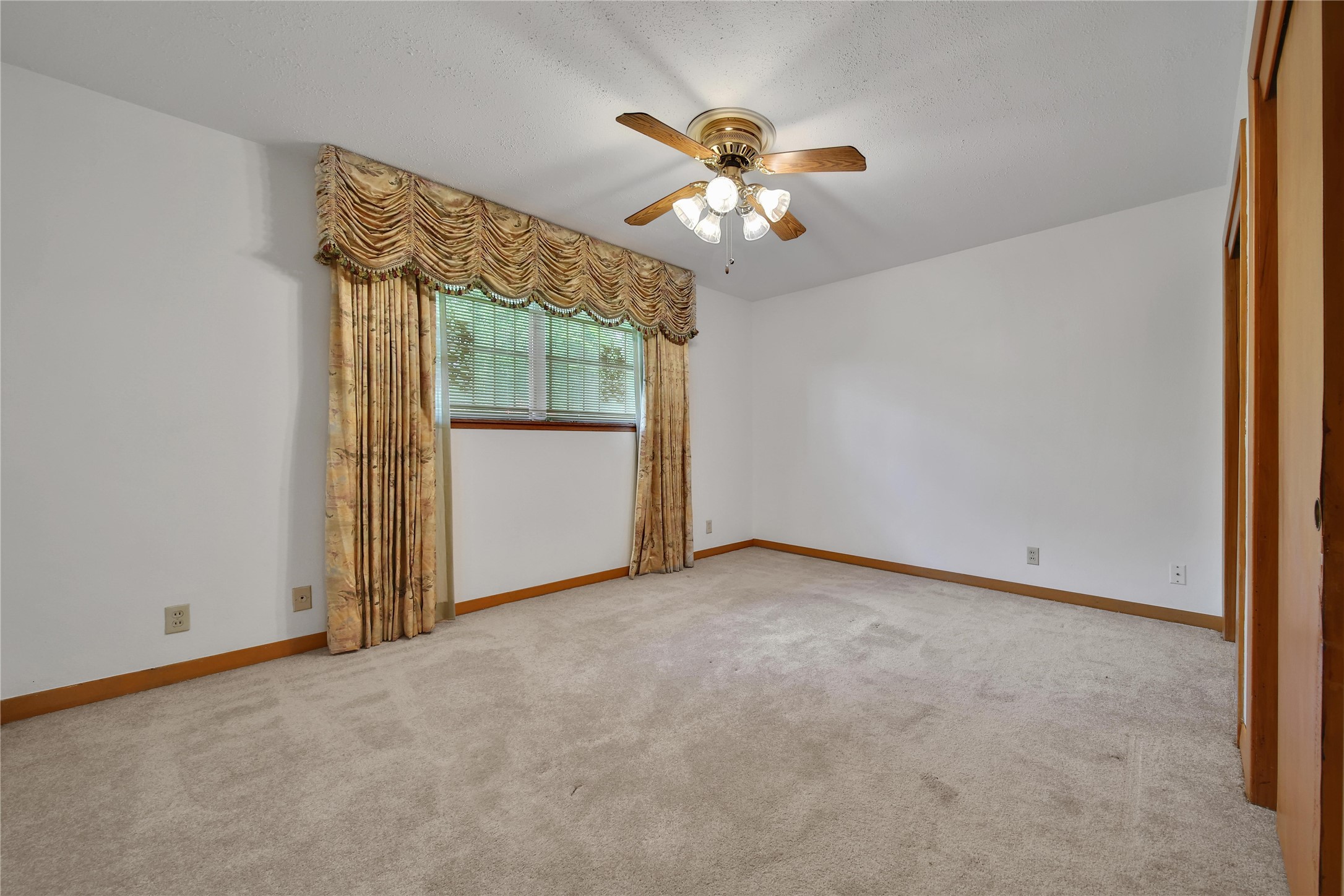115 East Thornton Road Houston, TX 77022 - Photo 21 of 40 an empty room with chandelier fan and windows