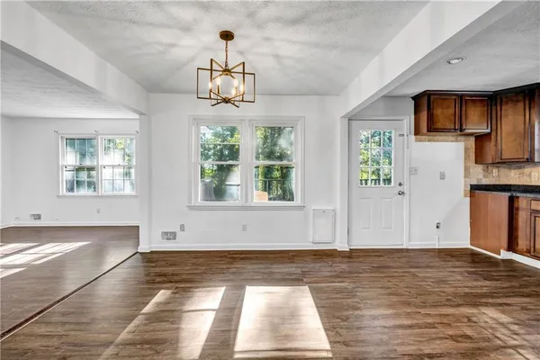 a view of empty room with wooden floor and window