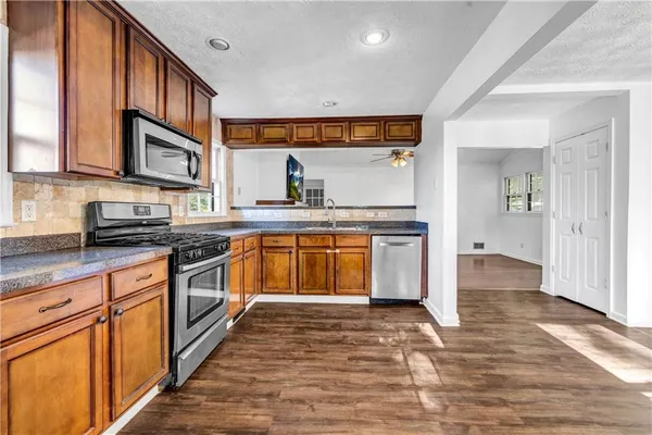 a kitchen with stainless steel appliances granite countertop a stove and a sink