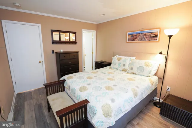 a bedroom with a bed and wooden floor