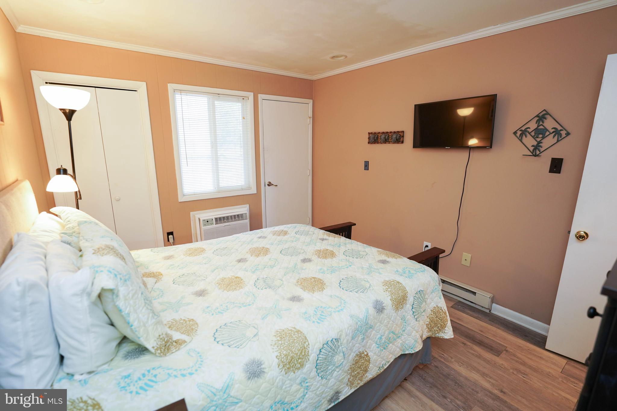 17 139th Street, Unit 101 Ocean City, MD 21842 - Photo 18 of 28 a bedroom with a bed tv and wooden floor