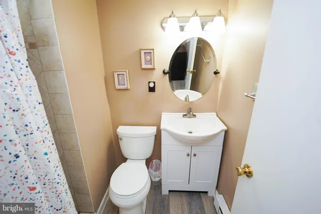 a white toilet sitting next to a sink and a mirror