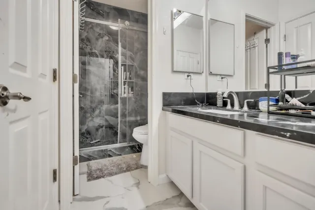 a bathroom with a granite countertop sink mirror and shower