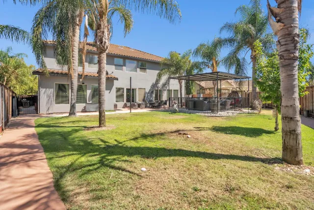 a view of a house with a swimming pool and a small yard