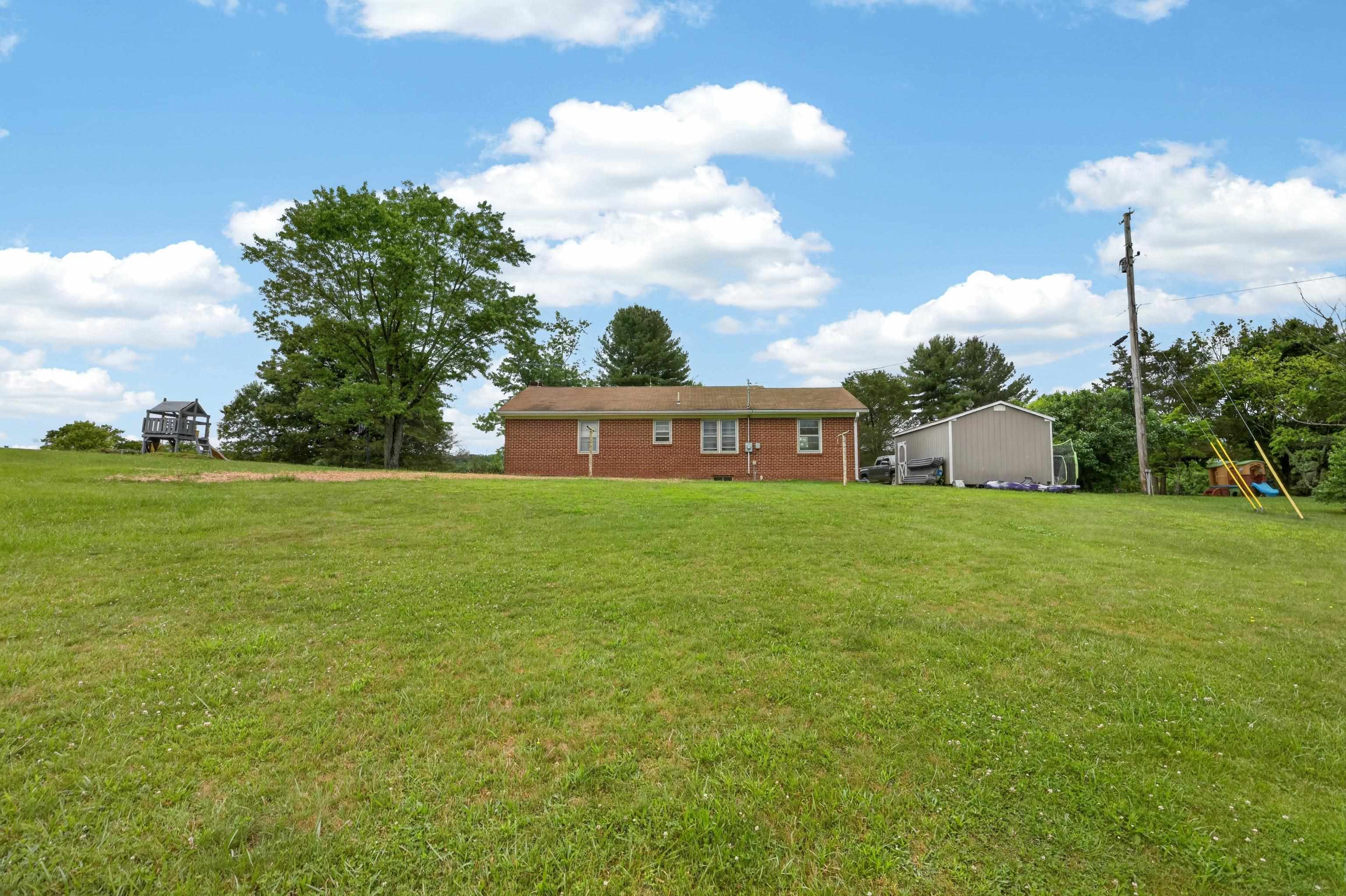7827 Lee Highway Raphine, VA 24472 - Photo 44 of 62 a front view of house with yard and trees in the background
