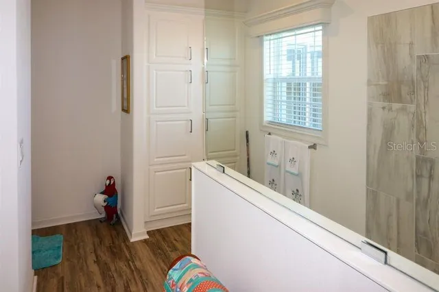 a hallway with wooden floor and closet