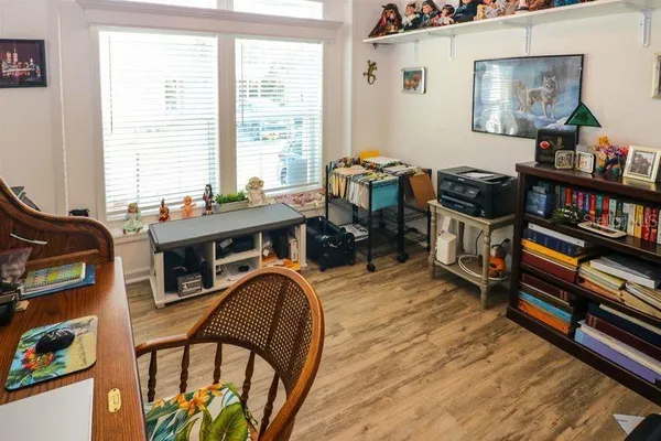 a view of a workspace with furniture and a book shelf