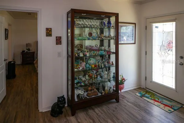 a view of a hallway with wooden floor and a living room