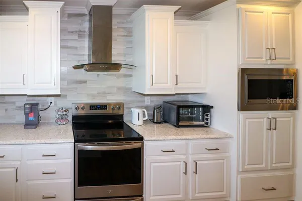 a kitchen with white cabinets and black appliances