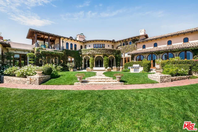 a view of a house with a big yard and large trees