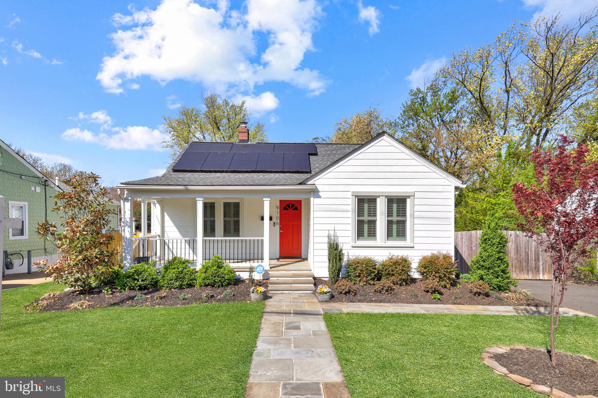 a front view of a house with a yard and potted plants