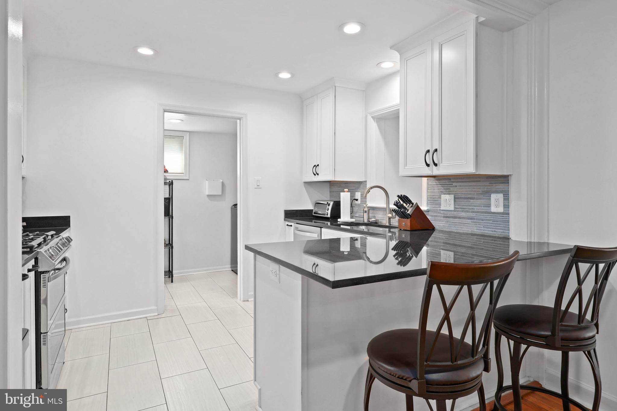 9106 Battle Street Manassas, VA 20110 - Photo 20 of 50 a kitchen that has a table chairs in it and white cabinets
