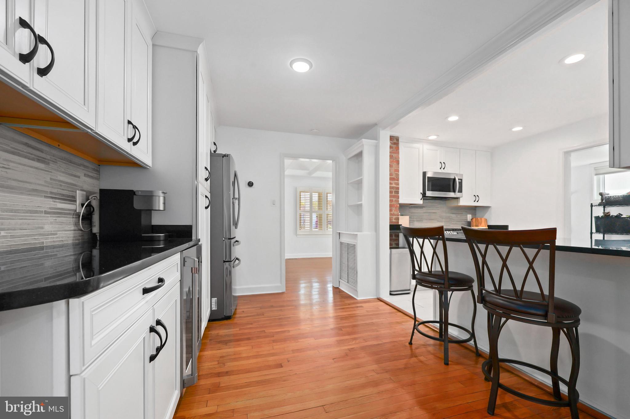 9106 Battle Street Manassas, VA 20110 - Photo 27 of 50 a kitchen with stainless steel appliances kitchen island granite countertop a table chairs microwave and sink