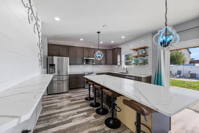 a large kitchen with stainless steel appliances kitchen island granite countertop a sink and cabinets