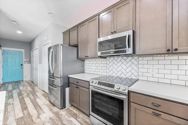 a kitchen with granite countertop a sink stove and refrigerator