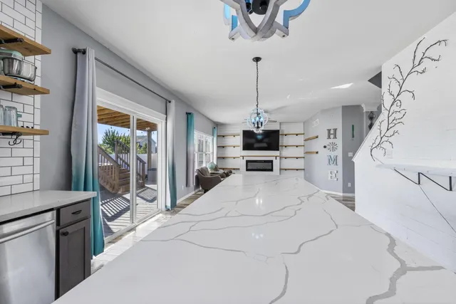 a large white kitchen with a large window appliances and furniture